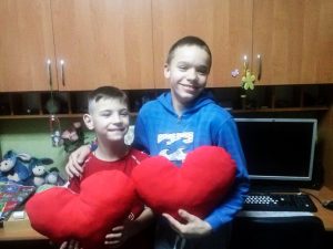 Twee jongens poseren met een zelfgemaakt hart